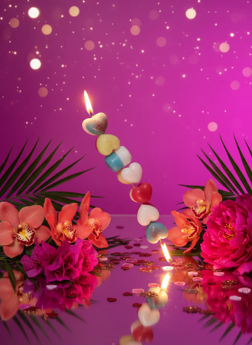 Colorful  row of heart-shaped  candles with flowers and a party purple theme